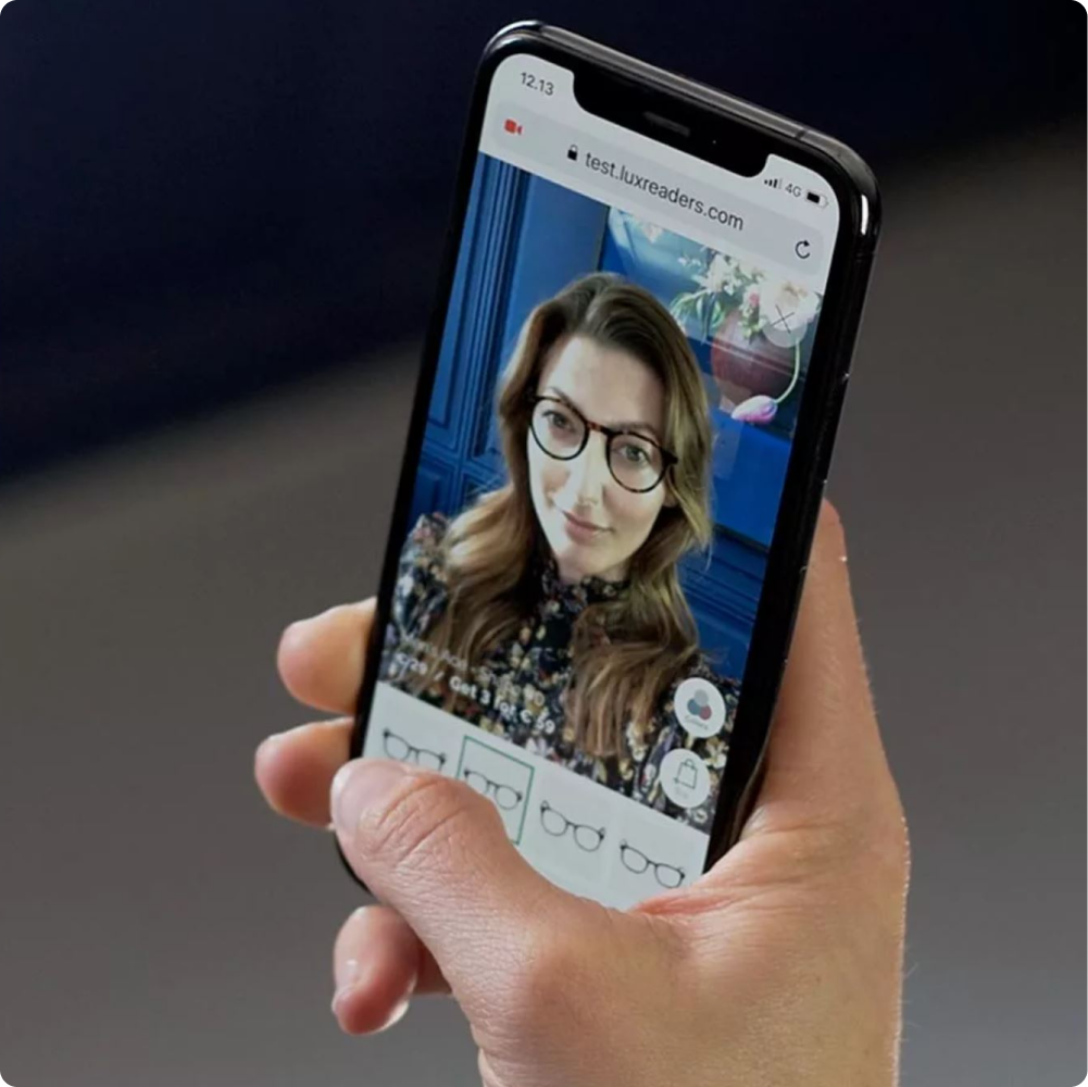 Dame prøver briller i vårt digitale prøverom med sin mobiltelefon