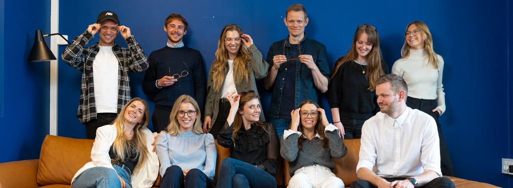 Gruppebilde av 11 ansatte i Luxreaders som smiler og har på seg briller