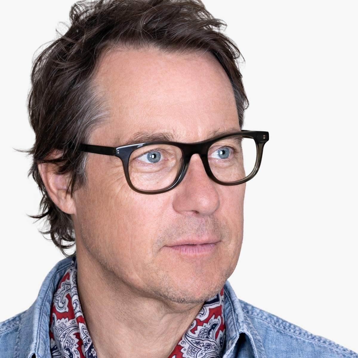 Person wearing Malmö Shiny Olive glasses with dark frames